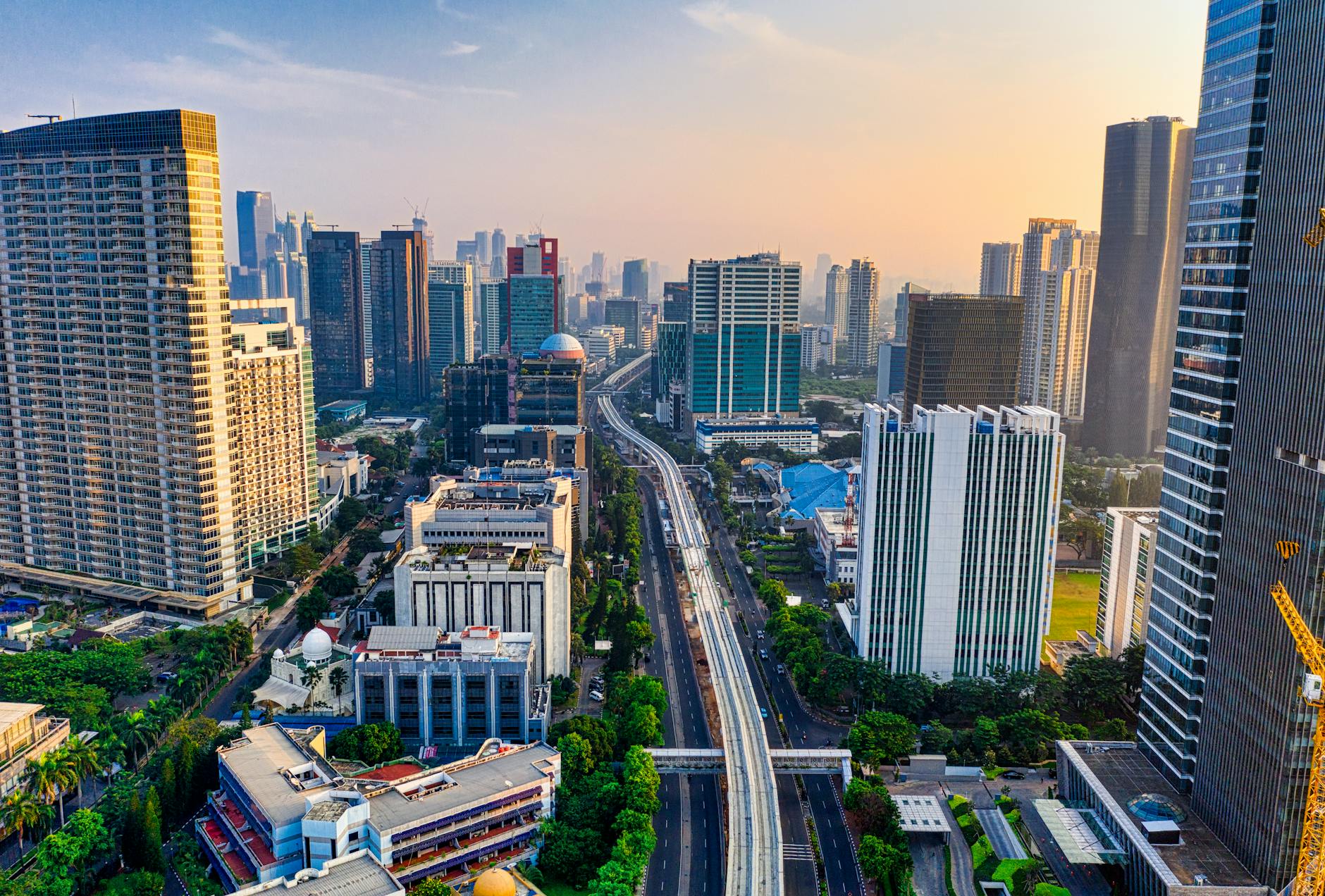 Aerial view showcasing a cityscape with tall skyscrapers and urban architecture at dusk.