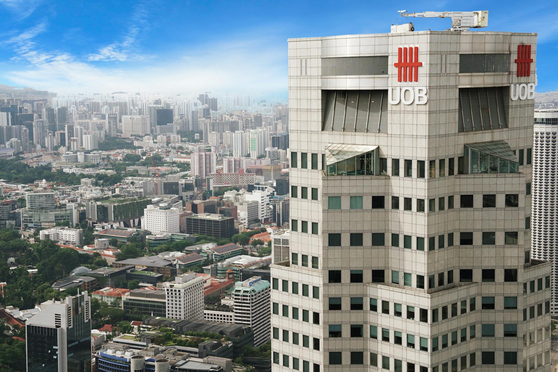Aerial view of UOB Tower with the sprawling cityscape of Singapore in the background.